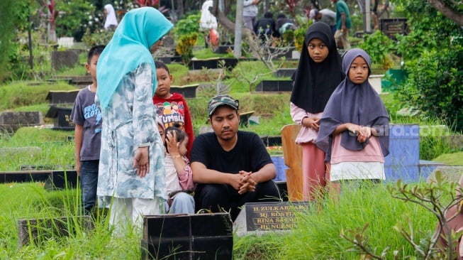 Warga melakukan ziarah kubur di TPU Karet Bivak, Jakarta, Sabtu (22/2/2025). [Suara.com/Alfian Winanto]
