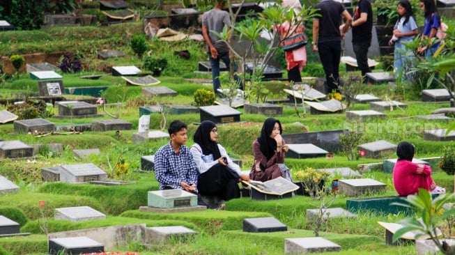 Warga melakukan ziarah kubur di TPU Karet Bivak, Jakarta, Sabtu (22/2/2025). [Suara.com/Alfian Winanto]
