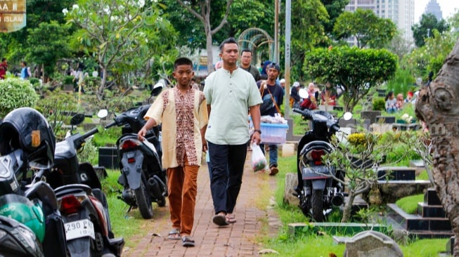 Warga melakukan ziarah kubur di TPU Karet Bivak, Jakarta, Sabtu (22/2/2025). [Suara.com/Alfian Winanto]
