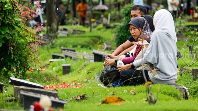 Warga melakukan ziarah kubur di TPU Karet Bivak, Jakarta, Sabtu (22/2/2025). [Suara.com/Alfian Winanto]
