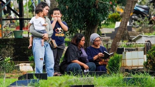 Warga melakukan ziarah kubur di TPU Karet Bivak, Jakarta, Sabtu (22/2/2025). [Suara.com/Alfian Winanto]
