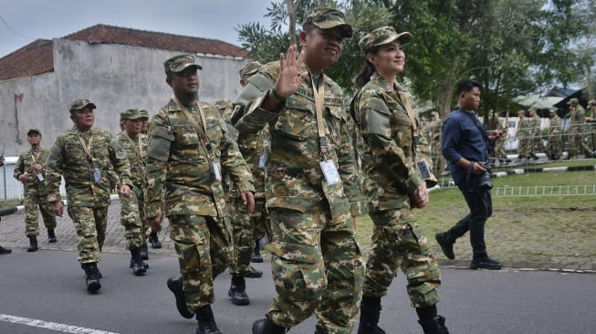 Gubernur Jawa Barat Dedi Mulyadi (kiri) bersama Gubernur Maluku Utara Sherly Laos (kanan) mengenakan seragam komponen cadangan (komcad) menyapa warga setibanya di Kompleks Akademi Militer Magelang, Jawa Tengah, Jumat (21/2/2025). Sebanyak 450 kepala daerah dari seluruh Indonesia akan mengikuti retret pada 21- 28 Februari 2025. ANTARA FOTO/Anis Efizudin/rwa. 