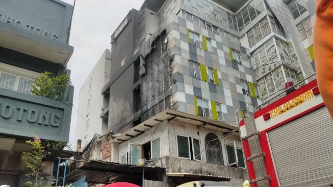 Asap sisa kebakaran masih mengepul dari dalam bangunan Hotel 101 Urban di Jalan Pasar Glodok Selatan RT 01 RW 01 Kelurahan Tamansari, Kecamatan Tamansari, Jakarta Barat pada Selasa (25/2/2025) pagi. (ANTARA/Risky Syukur)