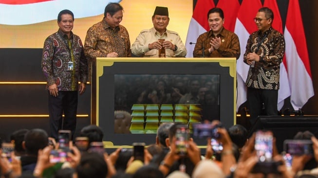 Presiden Prabowo Subianto (tengah) didampingi Menteri Koordinator Bidang Perekonomian Airlangga Hartarto (kedua kiri), Menteri BUMN Erick Thohir (kedua kanan), Dirut Pegadaian Damar Latri Setiawan (kanan), dan Dirut Bank Syariah Indonesia Hery Gunardi (kiri) memasukkan emas batangan saat meresmikan Layanan Bank Emas Pengadaian dan Bank Syariah Indonesia di The Gade Tower, Jakarta, Rabu (26/2/2025). [ANTARA FOTO/Muhammad Adimaja/tom]