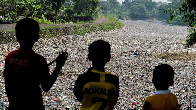 Tiga orang anak memperhatikan sampah yang menumpuk di Sungai Citarum Lama di Cicukang, Margaasih, Kabupaten Bandung, Jawa Barat, Kamis (27/2/2025). [ANTARA FOTO/Raisan Al Farisi/foc]