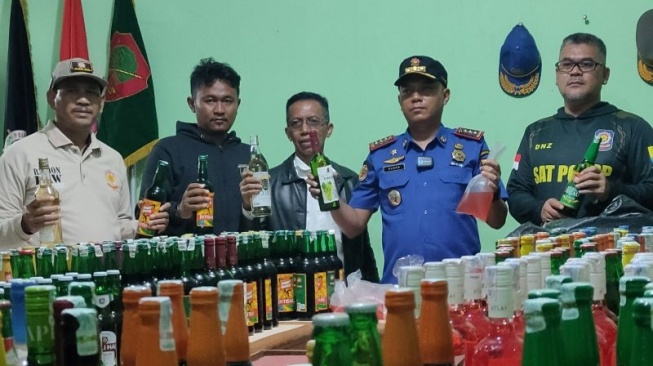 Kepala Satpol PP dan Damkar Kabupaten Cianjur, Jawa Barat, mengamankan ratusan botol miras berbagai merek dari kios berkedok depot jamu di sejumlah wilayah di Cianjur, Jumat (28/2/2025).(ANTARA/Ahmad Fikri).