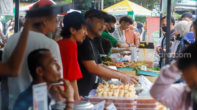 Warga berdesakan untuk membeli makanan yang dijual di Bazar Takjil, Bendungan Hilir, Jakarta, Senin (3/3/2025). [Suara.com/Alfian Winanto]