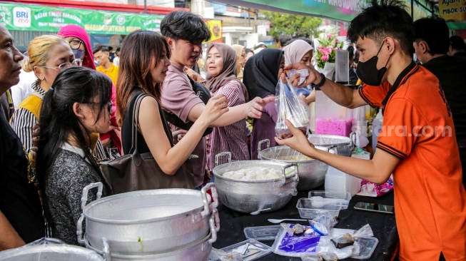 Warga berdesakan untuk membeli makanan yang dijual di Bazar Takjil, Bendungan Hilir, Jakarta, Senin (3/3/2025). [Suara.com/Alfian Winanto]