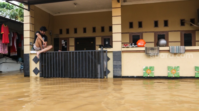 Warga beraktivitas di tengah banjir yang melanda di kawasan Tanjung Sanyang, Cawang, Jakarta, Senin (3/3/2025). [Suara.com/Alfian Winanto]
