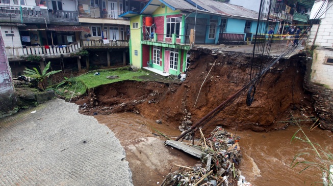 Jembatan dan jalan terputus akibat diterjang banjir bandang di Kampung Pensiunan, Desa Tugu Selatan, Cisarua, Kabupaten Bogor, Jawa Barat, Senin (3/3/2025). [ANTARA FOTO/Yulius Satria Wijaya/YU]