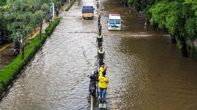 Sejumlah kendaraan menerobos banjir di Jalan Perjuangan, Kebon Jeruk, Jakarta, Selasa (4/3/2025). [ANTARA FOTO/Fathul Habib Sholeh/sgd/tom]