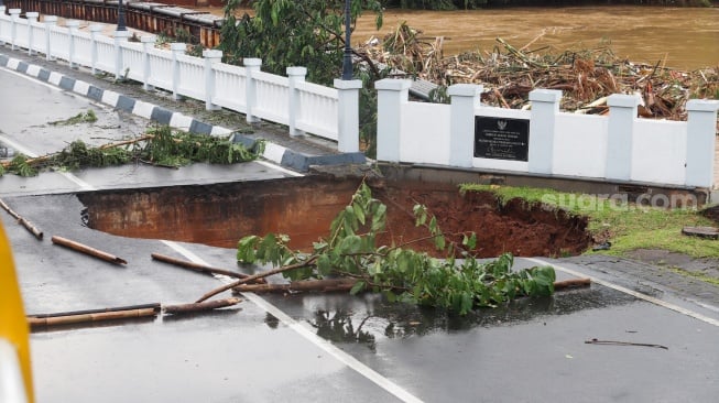 Kondisi jembatan yang amblas di kawasan perumahan Kemang Pratama, Bekasi, Jawa Barat, Selasa (4/3/2025). [Suara.com/Alfian Winanto]