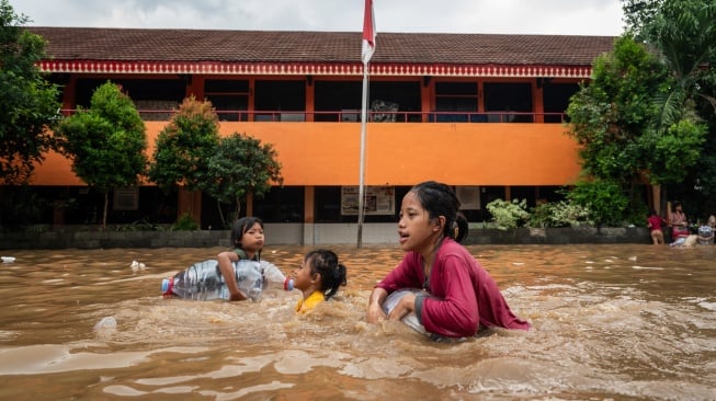 Anak-anak bermain air di halaman SD Negeri 22 Pejaten Timur yang terendam banjir di Jakarta, Selasa (4/3/2025). [ANTARA FOTO/Bayu Pratama S/tom]