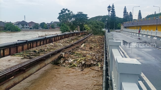 Kondisi jembatan yang dipenuhi sampah kiriman di kawasan perumahan Kemang Pratama, Bekasi, Jawa Barat, Selasa (4/3/2025). [Suara.com/Alfian Winanto]