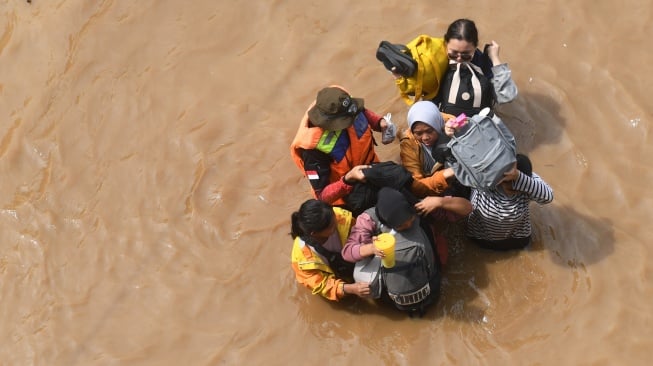 Warga melintasi banjir di kawasan Cililitan, Jakarta, Selasa (4/3/2025). [ANTARA FOTO/Akbar Nugroho Gumay/agr]