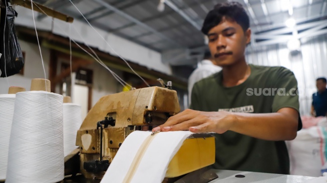 Pekerja menjahit bahan untuk dijadikan mukena di Pondok Aren, Tangerang Selatan, Rabu (5/3/2025). [Suara.com/Alfian Winanto]