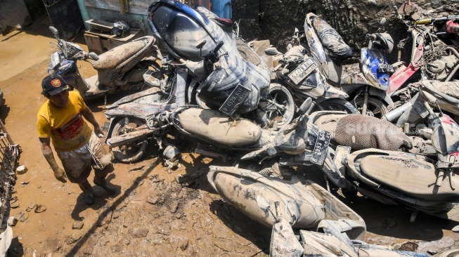 Warga mengamati mobil dan motor yang terdampak banjir luapan Kali Bekasi di Sekolah Permata Sakti di Perumahan Pondok Gede Permai (PGP), Jatirasa, Bekasi, Jawa Barat, Rabu (5/3/2025). [ANTARA FOTO/Fakhri Hermansyah/foc]