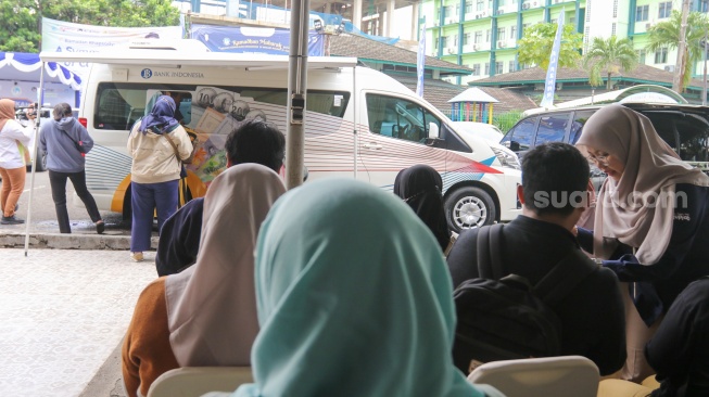 Warga menukarkan uang di Layanan Mobil Kas Keliling Bank Indonesia di Kompleks Masjid Al-Azhar, Jakarta, Rabu (5/3/2025). [Suara.com/Alfian Winanto]