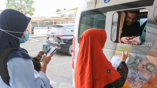 Warga menukarkan uang di Layanan Mobil Kas Keliling Bank Indonesia di Kompleks Masjid Al-Azhar, Jakarta, Rabu (5/3/2025). [Suara.com/Alfian Winanto]