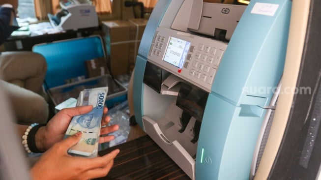 Warga menukarkan uang di Layanan Mobil Kas Keliling Bank Indonesia di Kompleks Masjid Al-Azhar, Jakarta, Rabu (5/3/2025). [Suara.com/Alfian Winanto]