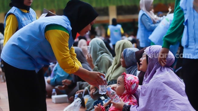 Panitia membagikan makanan takjil yang disediakan di Masjid Istiqlal, Jakarta, Kamis (6/3/2025). [Suara.com/Alfian Winanto]