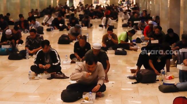 Umat Islam bersiap menyantap makanan takjil yang disediakan di Masjid Istiqlal, Jakarta, Kamis (6/3/2025). [Suara.com/Alfian Winanto]