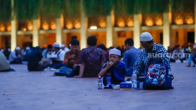 Umat Islam bersiap menyantap makanan takjil yang disediakan di Masjid Istiqlal, Jakarta, Kamis (6/3/2025). [Suara.com/Alfian Winanto]