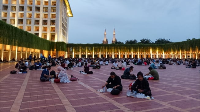 Umat Islam bersiap menyantap makanan takjil yang disediakan di Masjid Istiqlal, Jakarta, Kamis (6/3/2025). [Suara.com/Alfian Winanto]