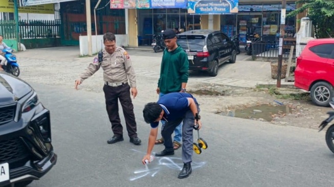 Polisi melakukan olah TKP di lokasi mobil mewah kecelakaan hingga menewaskan satu warga di Medan. [dok Polsek Medan Baru]