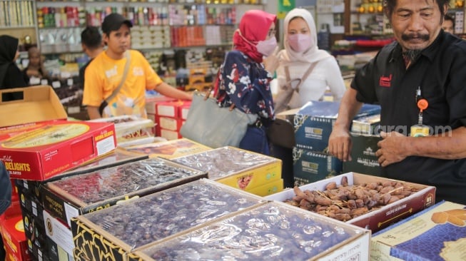 Pembeli memilih buah kurma di Pasar Tanah Abang, Jakarta, Rabu (12/3/2025). [Suara.com/Alfian Winanto]