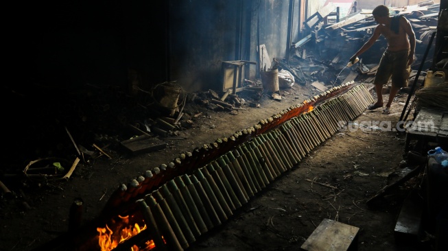 Pekerja menyelesaikan produksi lemang di kawasan Senen, Jakarta, Jumat (14/3/2025). [Suara.com/Alfian Winanto]
