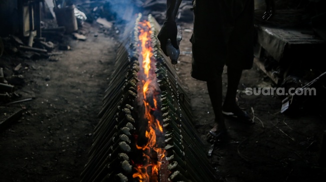 Pekerja menyelesaikan produksi lemang di kawasan Senen, Jakarta, Jumat (14/3/2025). [Suara.com/Alfian Winanto]
