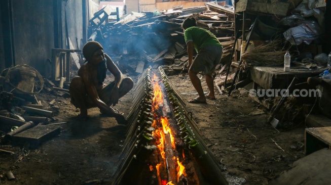 Pekerja menyelesaikan produksi lemang di kawasan Senen, Jakarta, Jumat (14/3/2025). [Suara.com/Alfian Winanto]
