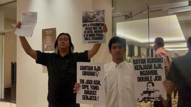 Aktivis dari Koalisi Masyarakat Sipil menggeruduk tempat Rapat Panja RUU TNI di Hotel Fairmont, Jakarta, Sabtu (15/3/2025). [Suara.com/Yaumal]