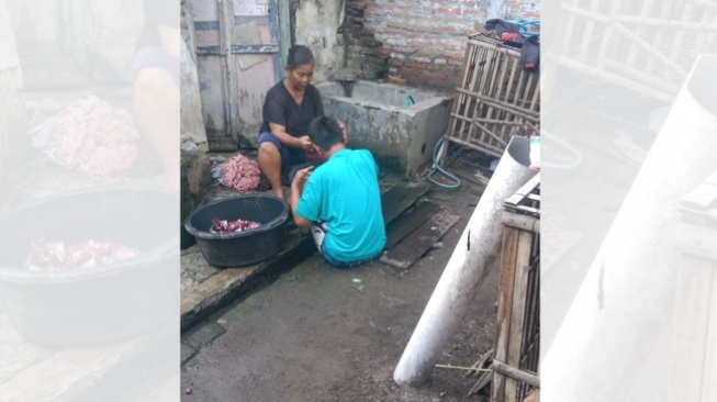 Parjiah sedang merawat anaknya penyandang disabilitas, Aminudin (Suara.com)
