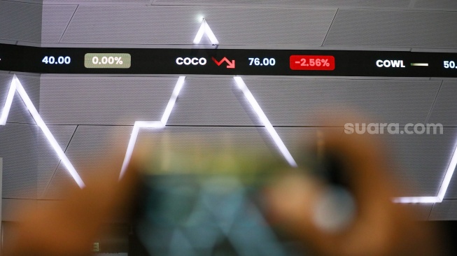 Pengunjung melihat layar pergerakan Indeks Harga Saham Gabungan (IHSG) di Bursa Efek Indonesia (BEI), Jakarta, Selasa (18/3/2025). [Suara.com/Alfian Winanto]