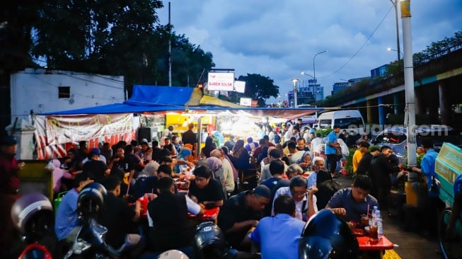 Pengunjung menunggu waktu berbuka puasa di Sentra kuliner Nasi Kapau di Jalan Kramat Raya, Senen, Jakarta, Selasa (18/3/2025). [Suara.com/Alfian Winanto]
