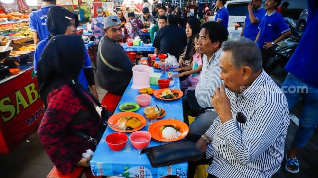 Pengunjung menunggu waktu berbuka puasa di Sentra kuliner Nasi Kapau di Jalan Kramat Raya, Senen, Jakarta, Selasa (18/3/2025). [Suara.com/Alfian Winanto]
