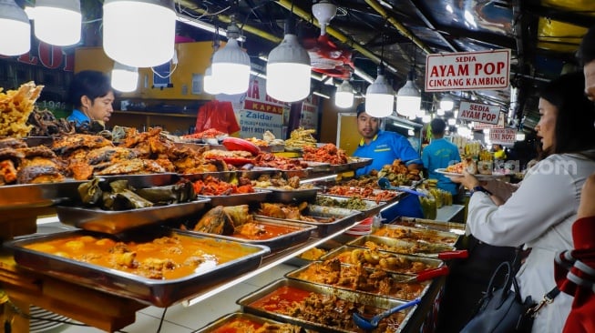 Pengunjung memilih menu berbuka puasa di Sentra kuliner Nasi Kapau di Jalan Kramat Raya, Senen, Jakarta, Selasa (18/3/2025). [Suara.com/Alfian Winanto]
