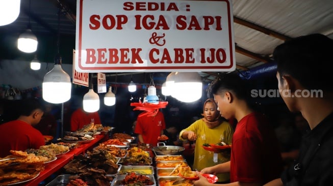 Pengunjung memilih menu berbuka puasa di Sentra kuliner Nasi Kapau di Jalan Kramat Raya, Senen, Jakarta, Selasa (18/3/2025). [Suara.com/Alfian Winanto]
