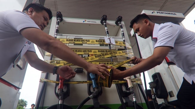 Polisi menyegel dispenser pom bensin Pertamina di Jalan Alternatif Sentul, Kabupaten Bogor, Jawa Barat, Rabu (19/3/2025). [ANTARA FOTO/Yulius Satria Wijaya/tom]