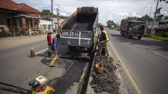 Pekerja melakukan penambalan jalan di jalur pantura Sukagumiwang, Indramayu, Jawa Barat, Senin (10/3/2025). Perbaikan jalan di jalur pantura tersebut untuk memberikan kenyamanan kepada pengguna jalan serta sebagai upaya mencegah terjadinya kecelakaan saat arus mudik Lebaran. ANTARA FOTO/Dedhez Anggara/tom. 