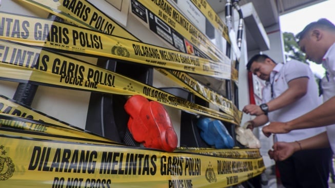 Polisi menyegel dispenser pom bensin Pertamina di Jalan Alternatif Sentul, Kabupaten Bogor, Jawa Barat, Rabu (19/3/2025). [ANTARA FOTO/Yulius Satria Wijaya/tom]