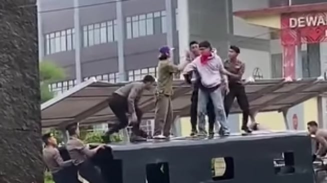 Video pendemo terlibat duel dengan aparat kepolisian di atas truk saat demo tolak RUU TNI di Gedung DPRD Sulut. (Tangkapan layar/Instagram)