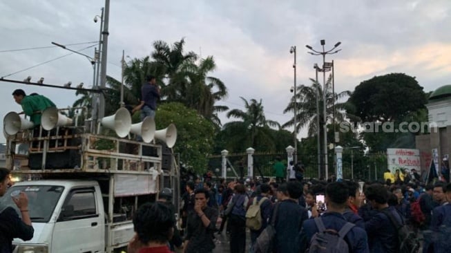 Aksi tolak Undang-Undang TNI yang digelar kalangan mahasiswa di depan Gedung DPR RI Jakarta masih berlanjut. Ketika waktu berbuka puasa tiba, dari atas mobil komando salah satu peserta aksi mengumandangkan azan. (Suara.com/Rakha)