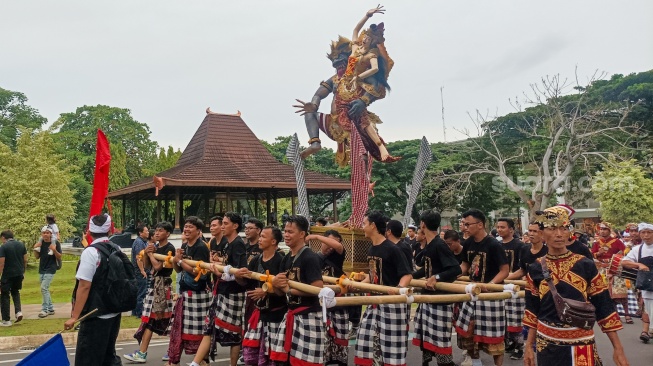 Umat Hindu mengarak ogoh-ogoh dalam Pawai Ogoh-Ogoh di Taman Mini Indonesia Indah (TMI), Jakarta, Sabtu (22/3/2025). [Suara.com/Alfian Winanto]
