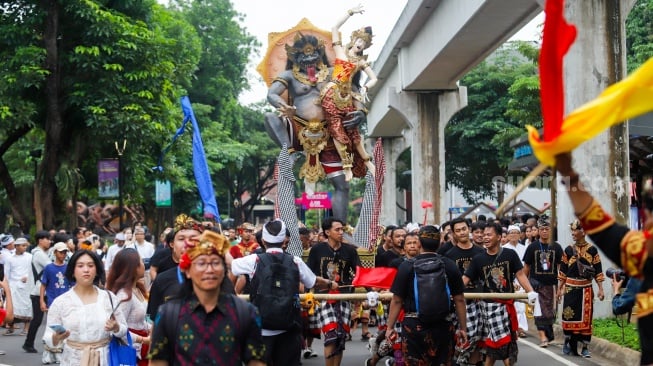 Umat Hindu mengarak ogoh-ogoh dalam Pawai Ogoh-Ogoh di Taman Mini Indonesia Indah (TMI), Jakarta, Sabtu (22/3/2025). [Suara.com/Alfian Winanto]
