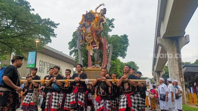 Umat Hindu mengarak ogoh-ogoh dalam Pawai Ogoh-Ogoh di Taman Mini Indonesia Indah (TMI), Jakarta, Sabtu (22/3/2025). [Suara.com/Alfian Winanto]
