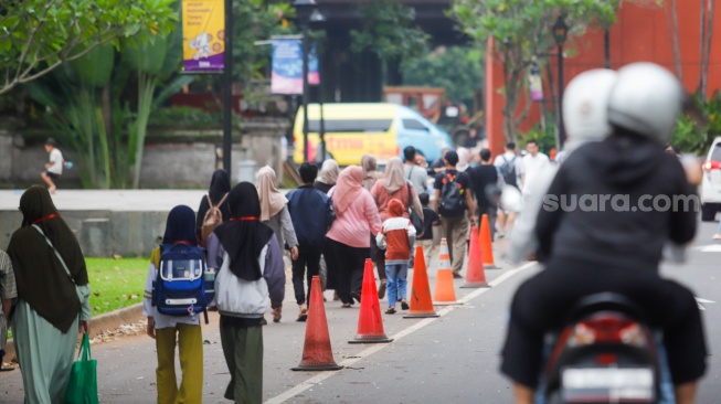 Warga beraktivitas menunggu waktu berbuka puasa di Taman Mini Indonesia Indah (TMII), Jakarta, Sabtu (22/3/2025). [Suara.com/Alfian Winanto]