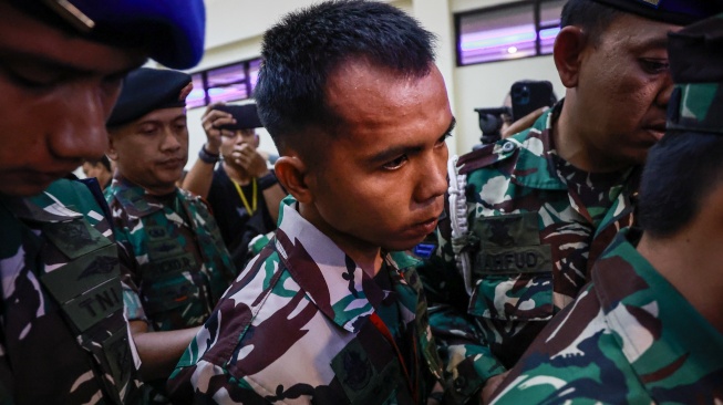 Terdakwa kasus pembunuhan bos rental mobil dan penadahan mobil, Kelasi Kepala Bambang Apri Atmojo (tengah) digiring petugas usai mengikuti sidang pembacaan putusan di Pengadilan Militer II-08 Jakarta, Selasa (25/3/2025). [ANTARA FOTO/Dhemas Reviyanto/tom]